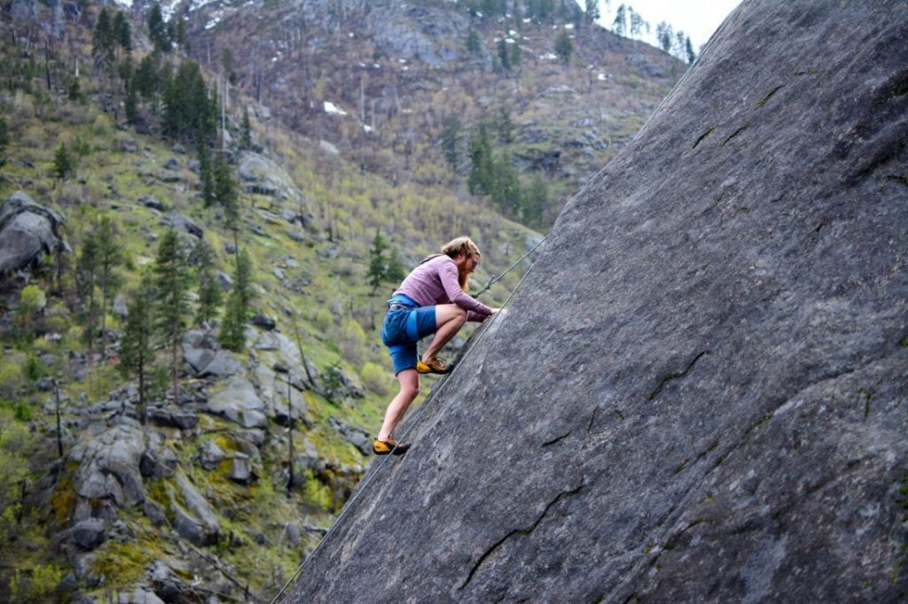 man climbing a slanted outdoor rock wall