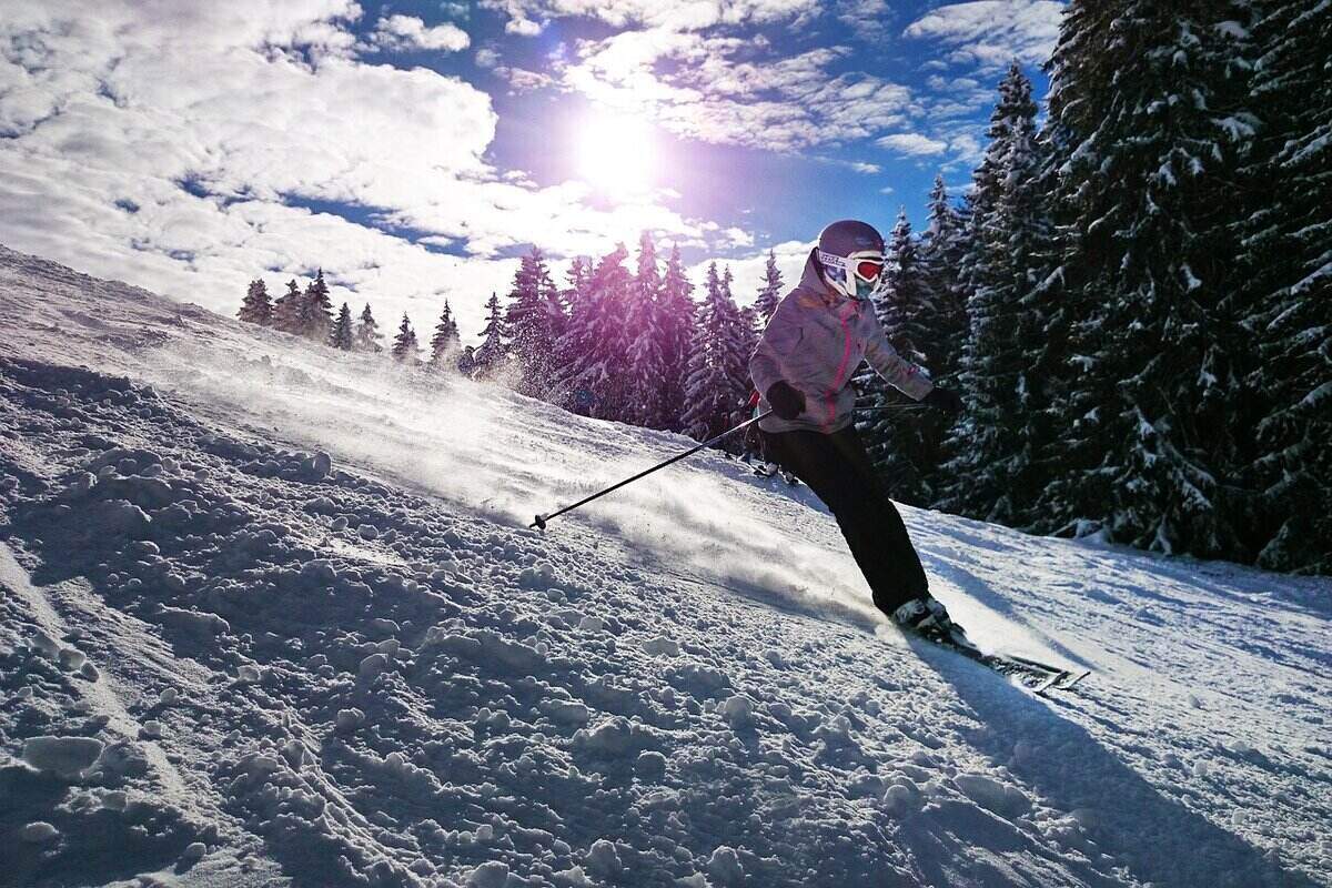Woman skiing down a slope with ski helmet headphones
