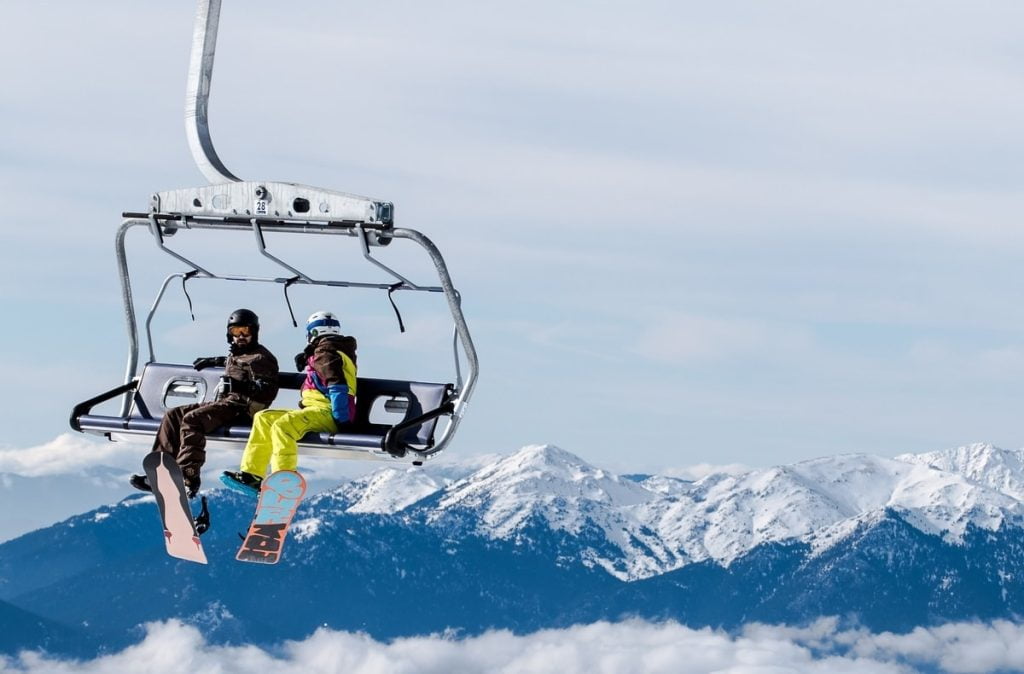 two skiers on a lifted chair lift