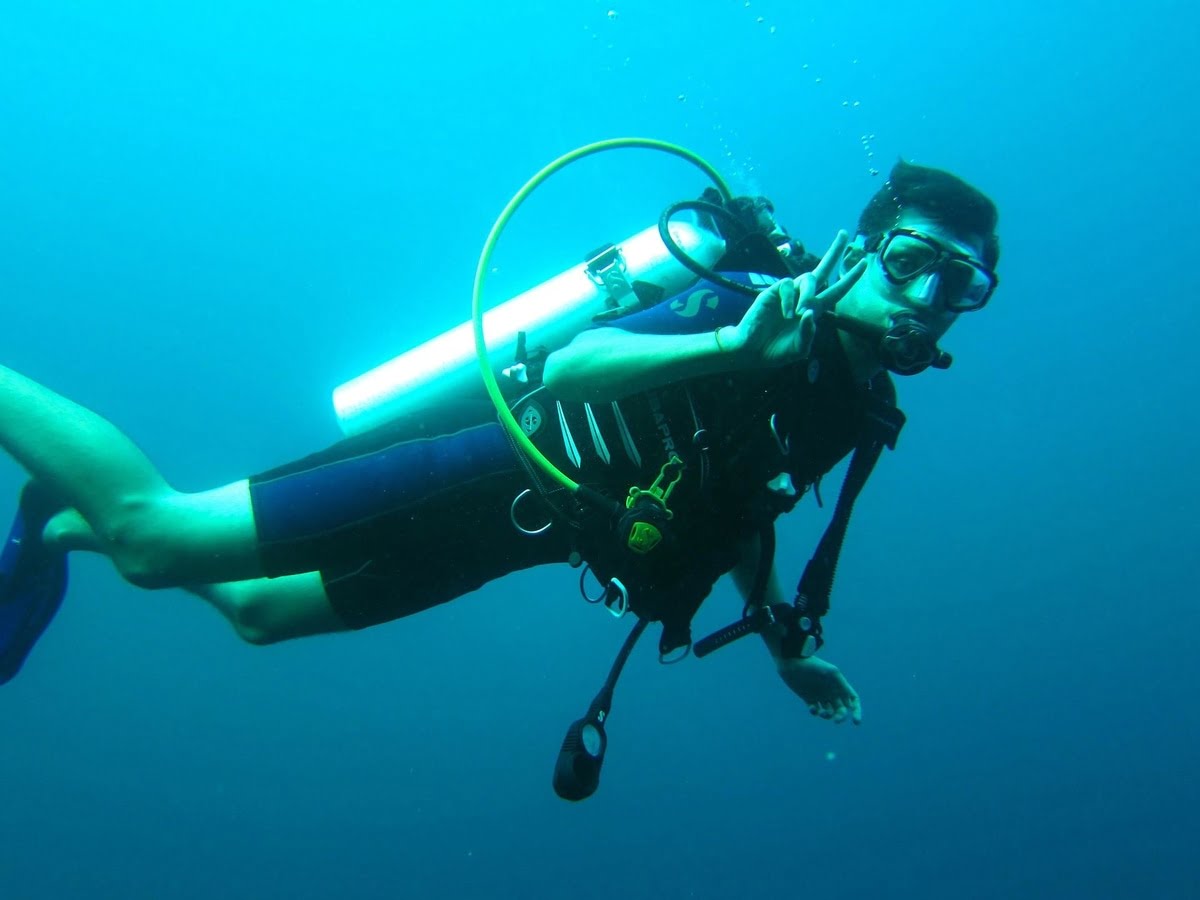 Scuba diver underwater showing peace sign