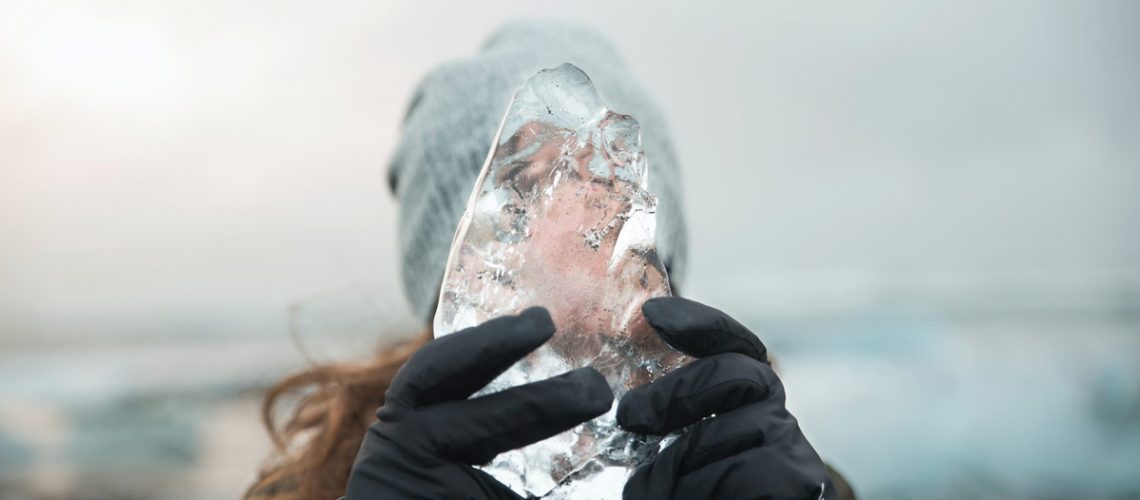 Waterproof winter gloves holding ice worn by a women